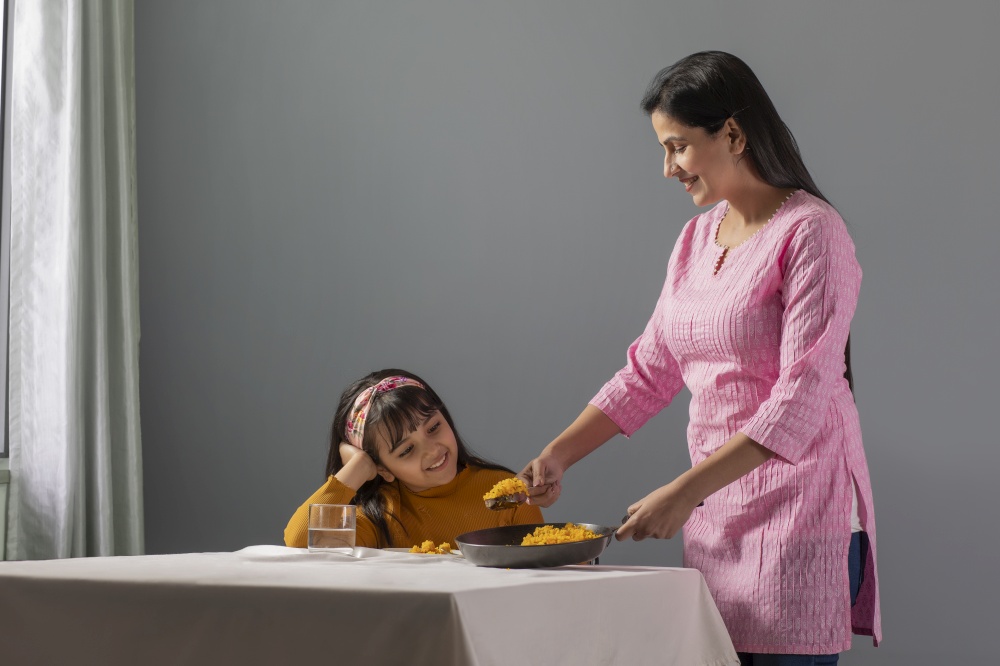 A HAPPY WOMAN SERVING FOOD TO DAUGHTER