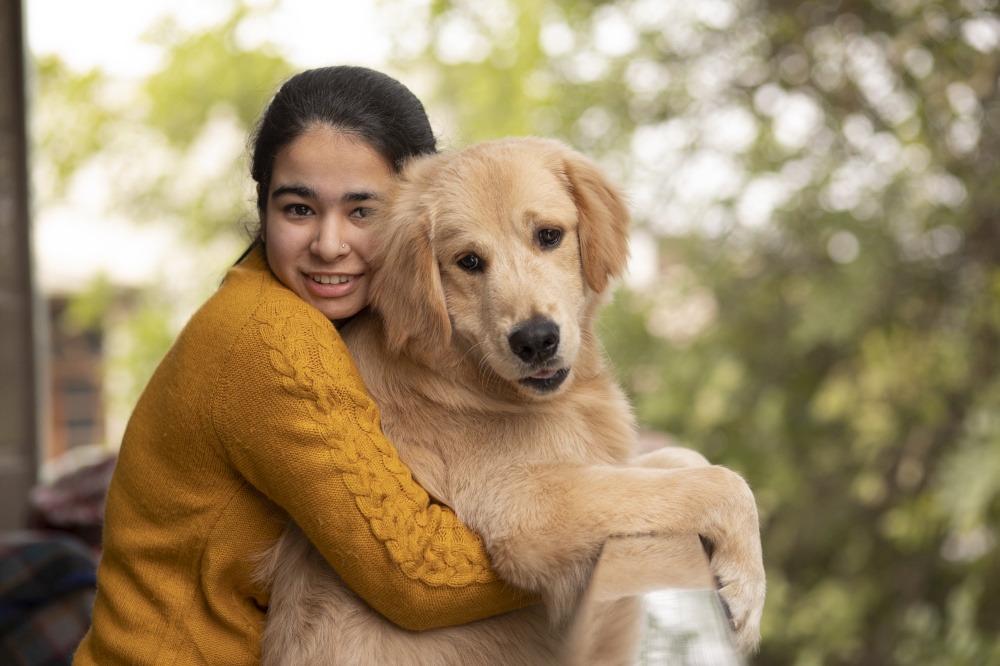 A YOUNG GIRL AND PET DOG LOOKING AT CAMERA AND POSING TOGETHER