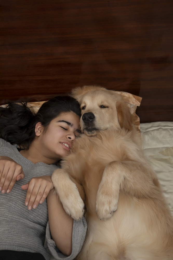 A YOUNG GIRL PLAYFULLY IMITATING PET DOG WHILE SLEEPING TOGETHER