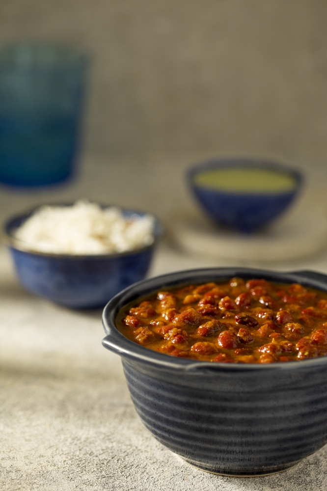 COOKED RAJMA CURRY SERVED ON A BOWL KEPT ALONG WITH RICE