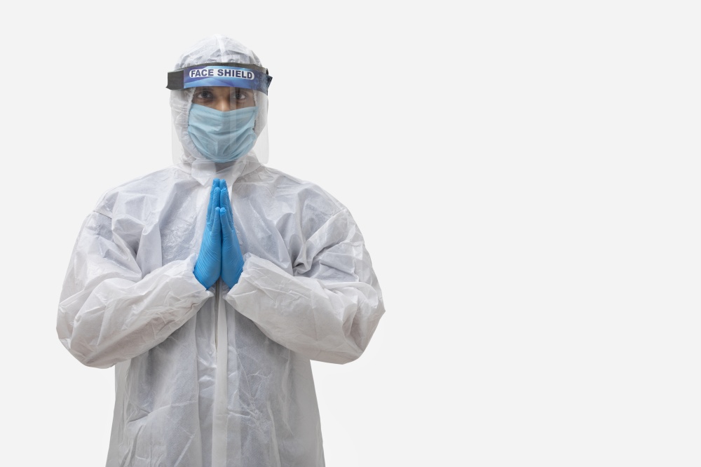 Man in a protective suit standing with his hands joined