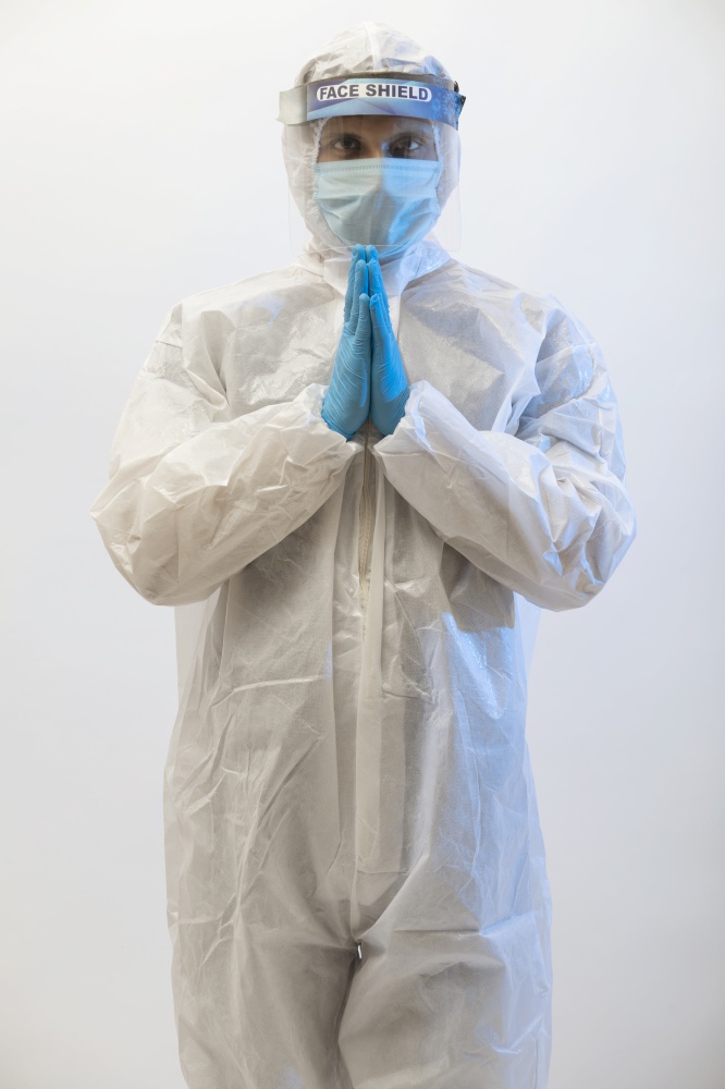 Man in a protective suit standing with his hands joined