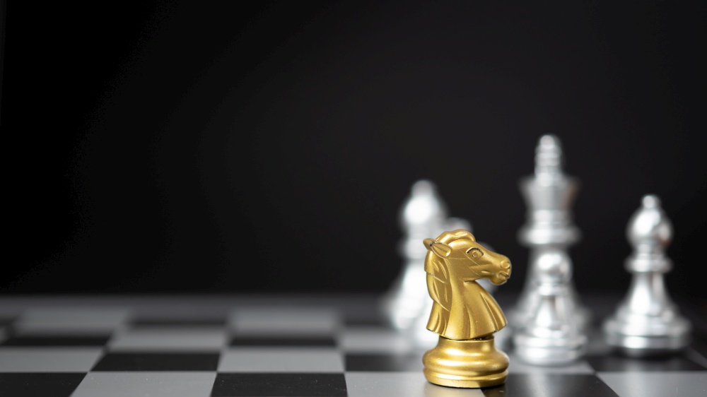 Strategy and business planning ideas. Chess horse gold on the board.