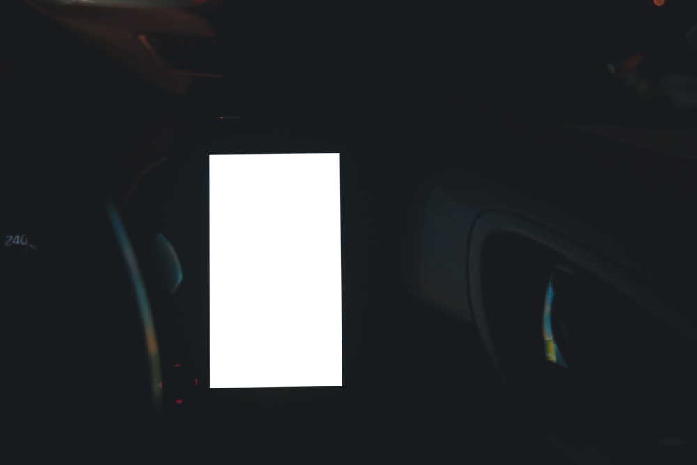 Mobile phone on the car air vent.Blank with white screen.Mock up smart phone in car.texting, copy space for your advertisement.