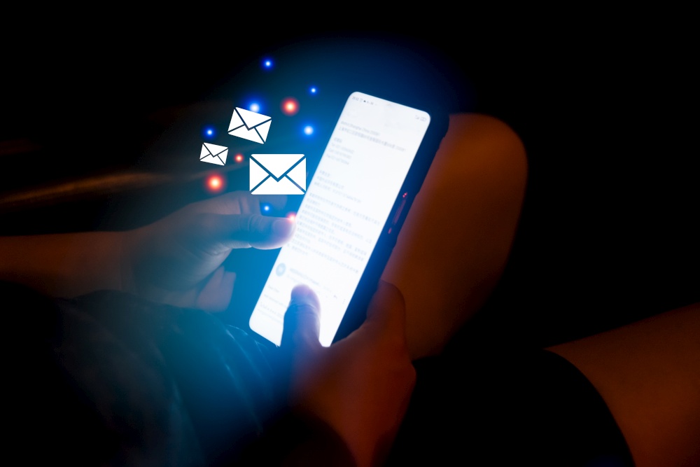 woman hand holding a phone checking email icon virtual screen in the car at night.Digital technology connection application message business concept.