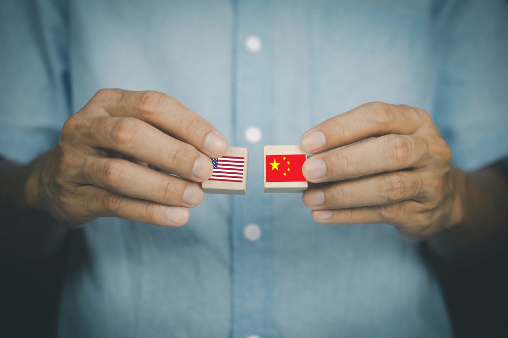 hand holding wood block concept business import export United States of America and China,US and China flag trading punches for the concept: Trade War.