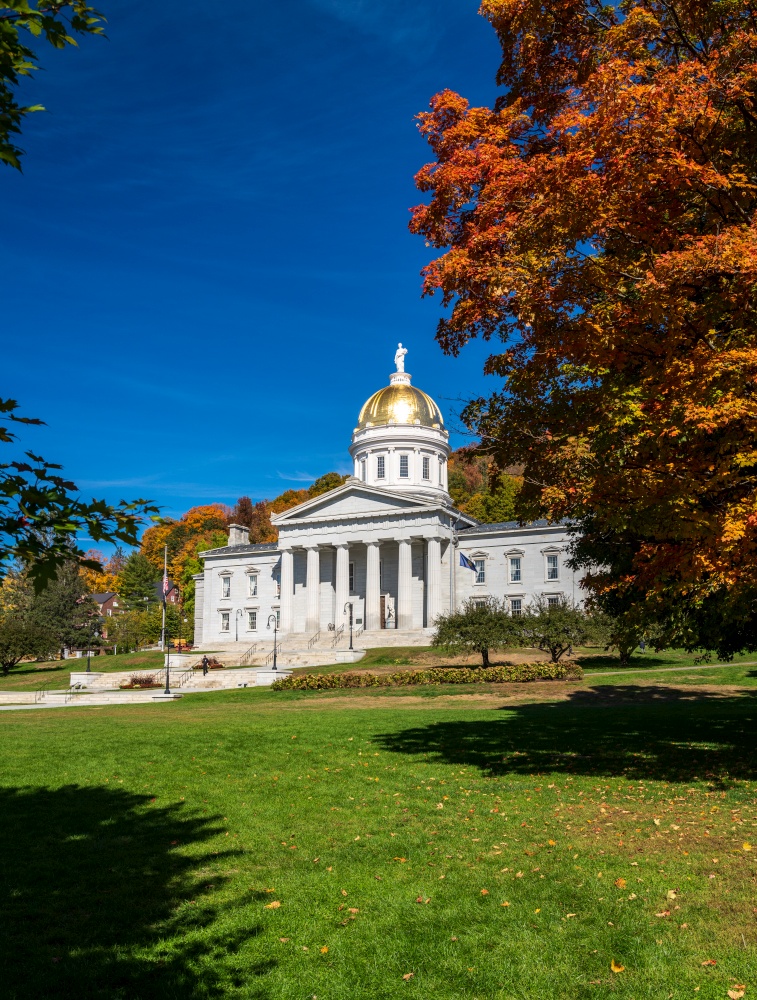 Gold leaf dome of the Vermont State House capitol building in Montpelier, Vermont. Brilliant fall colors surround the building. Gold dome of Vermont State House in Montpelier
