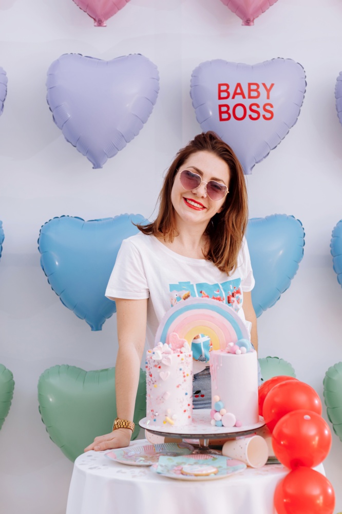 beautiful young woman in sunglasses with big birthday cake on many colorful heart balloons background. smiles,funny Valentines Day, birthday party.. beautiful young woman in sunglasses with big birthday cake on many colorful heart balloons background. smiles,funny Valentines Day, birthday party