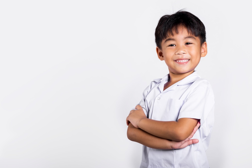 Asian toddler smile happy wearing student thai uniform red pants stand with arms folded in studio shot isolated on white background, Portrait little children boy preschool crossed arms, Back to school