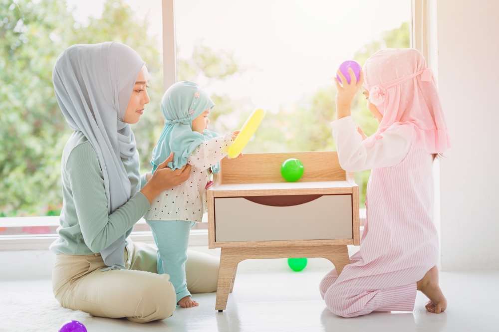 Muslim Arab family mother and her childs happy playing together at home cute and lovely.
