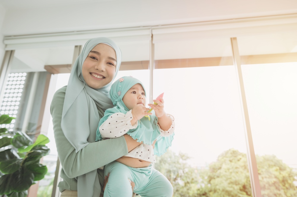 Muslim Hijab holding support her child baby happy smiling at home. mother care healthy infant looking camera.