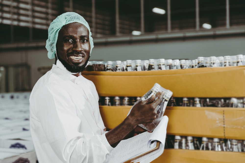 Black African worker working in industry factory products checking inventory stock in the warehouse. portrait looking camera smiling.