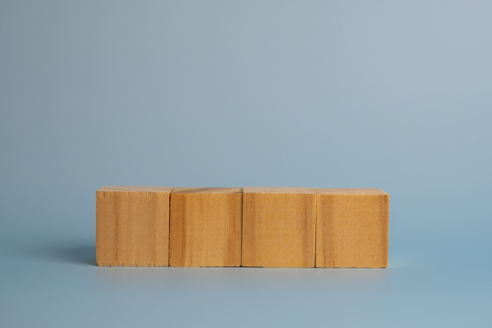Four blank wooden block cubes on background for your text. Business concept template and banner.
