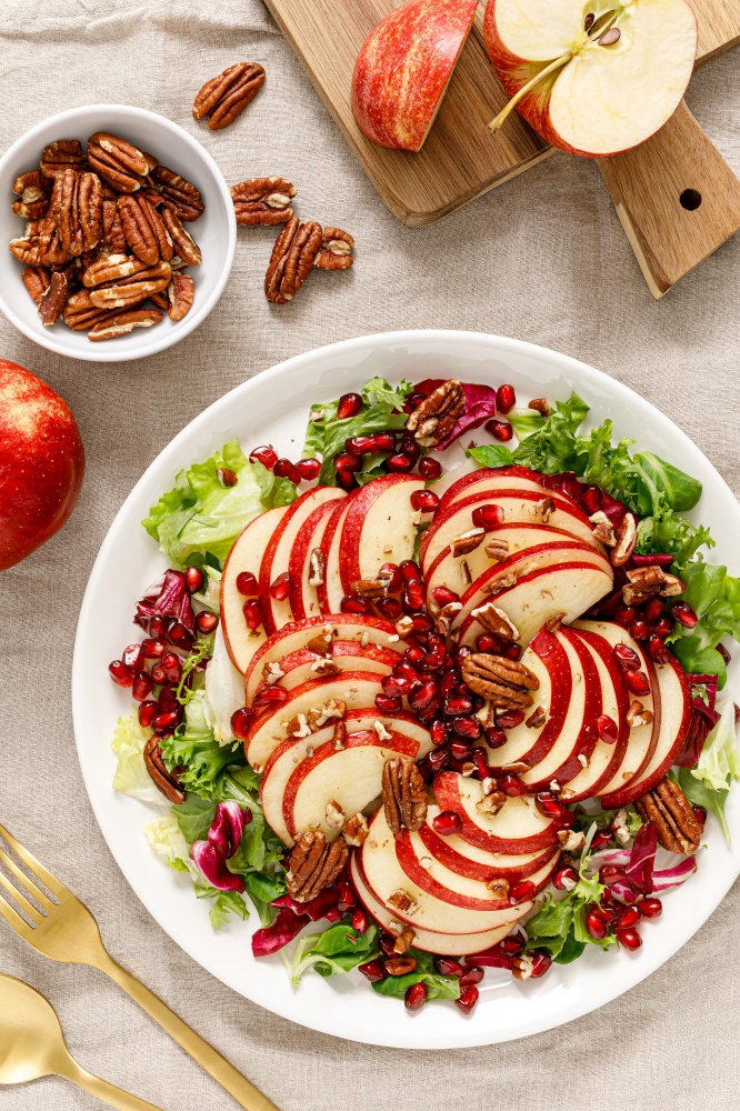 Salad with apple, pomegranate and pecan nut. Healthy food, top view