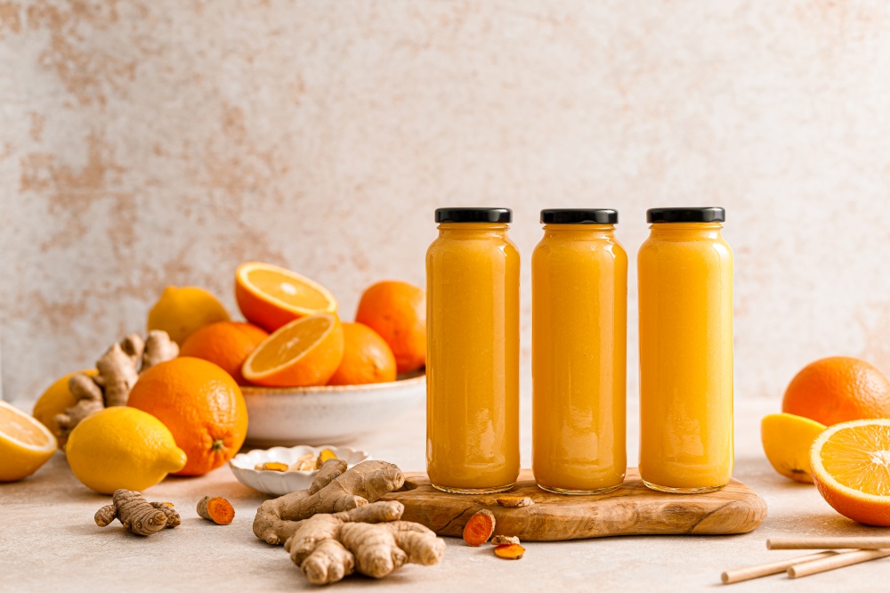 Smoothie. Healthy fresh raw detox citrus smoothie with orange, lemon, ginger and turmeric in a glass bottles on a table. Healthy diet vegan food full of antioxidants