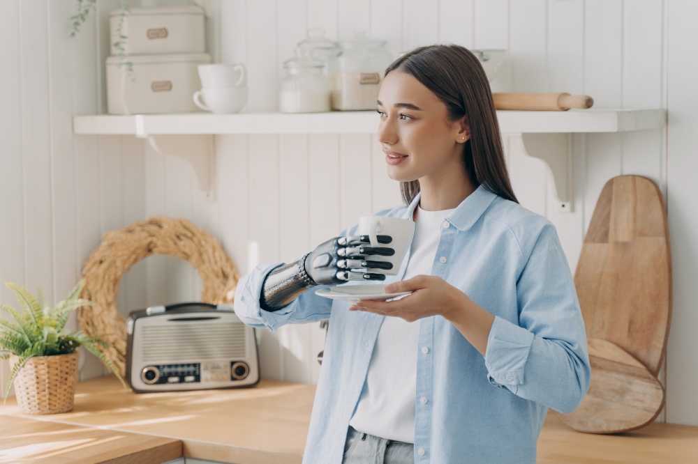 European disabled girl is holding cup with cyber hand. Woman has tea at domestic kitchen. Concept of grasp sensors in modern bionic prosthesis. Technologies and innovations for life quality.. European disabled girl is holding cup with cyber hand. Technologies for life quality.