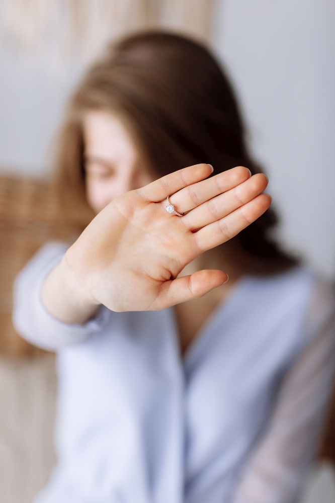 young woman shows a ring with diamond. The girl shows an engagement ring on her finger. she said yes. selective focus on hand. young woman shows a ring with diamond. The girl shows an engagement ring on her finger. she said yes. selective focus on hand.