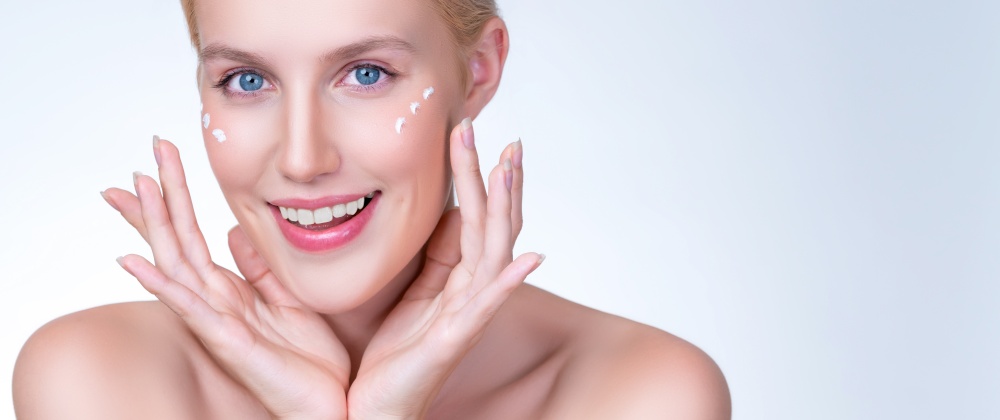 Personable beautiful perfect clean skin soft makeup woman finger applying moisturizer cream on her face under contour eye for anti aging wrinkle. Facial skin rejuvenation in isolated background.. Personable woman applying moisturizer cream on her face for perfect skin