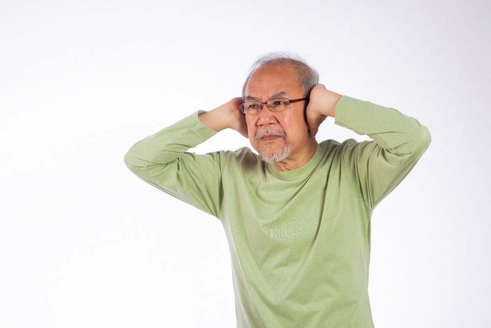 Deaf. Portrait senior old man with glasses sad covering ears with fingers hands studio shot isolated on yellow background, Asian unhappy elder man Suffering from a loud sound ignoring someone