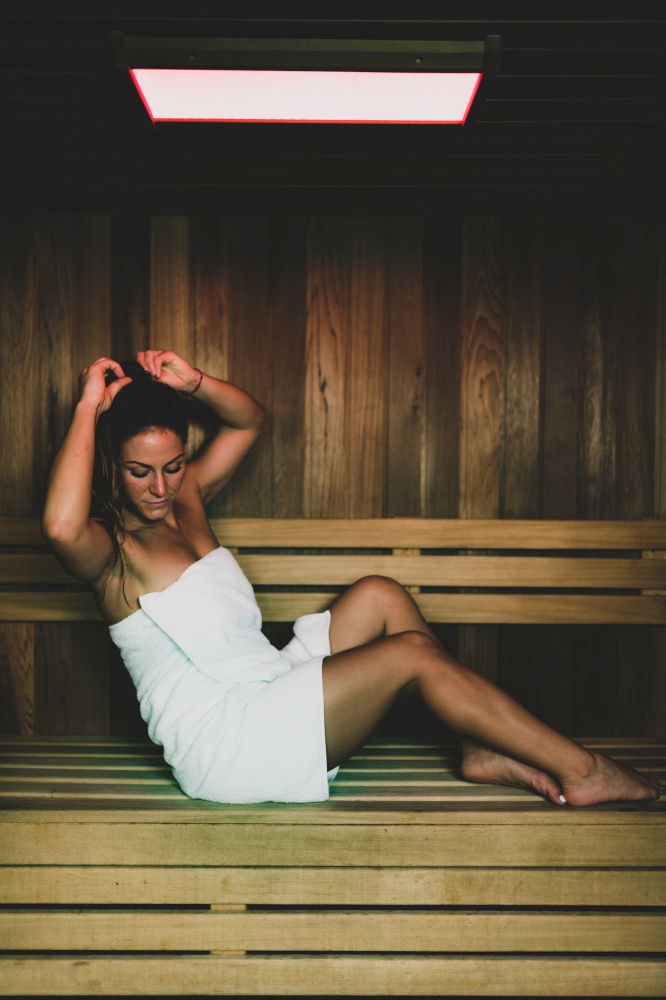 Woman Sitting and Relaxing in Hot Sauna.. Woman in Sauna