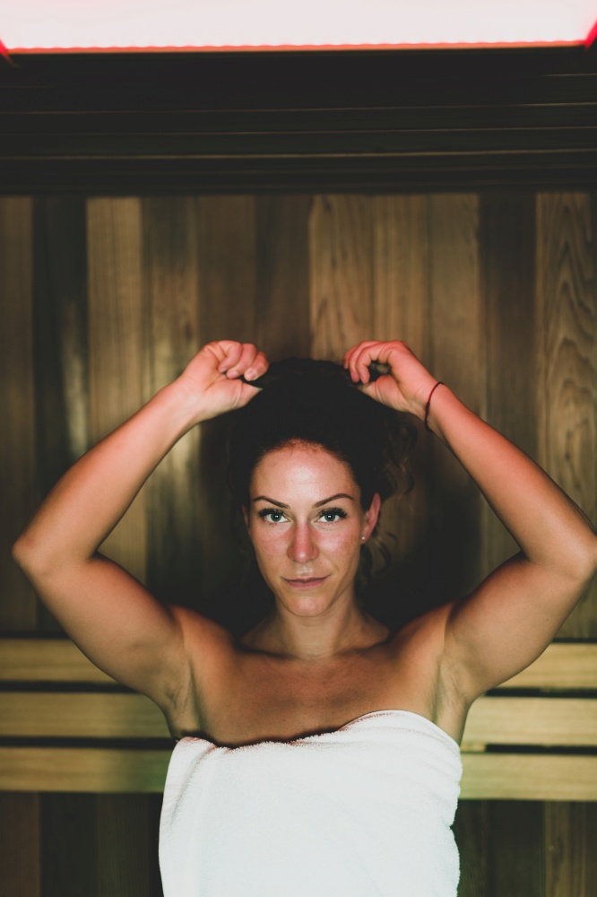 Woman Sitting and Relaxing in Hot Sauna.. Woman in Sauna
