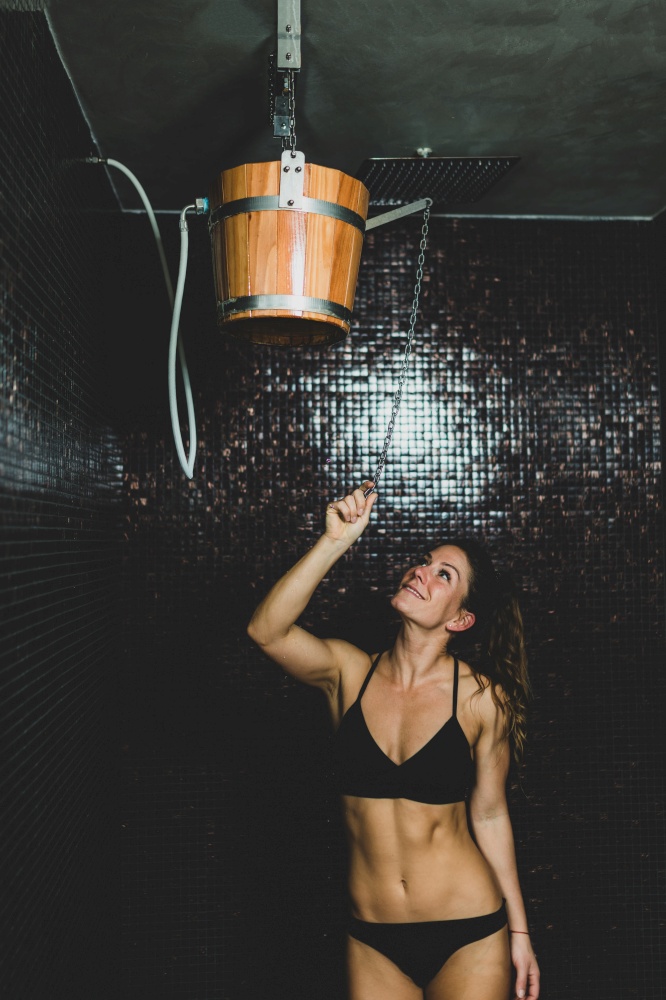 Beautiful Woman Having an Ice Cold Shower Bucket after Sauna.. Beautiful Woman Under the Ice Cold Shower Bucket