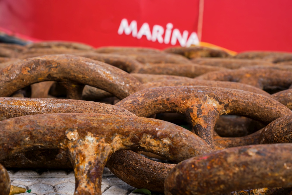 Close-up on the links of an old rusty ship&quot;s chain in the marina, selective focus. Idea for the background, the concept of shipping and recycling of materials