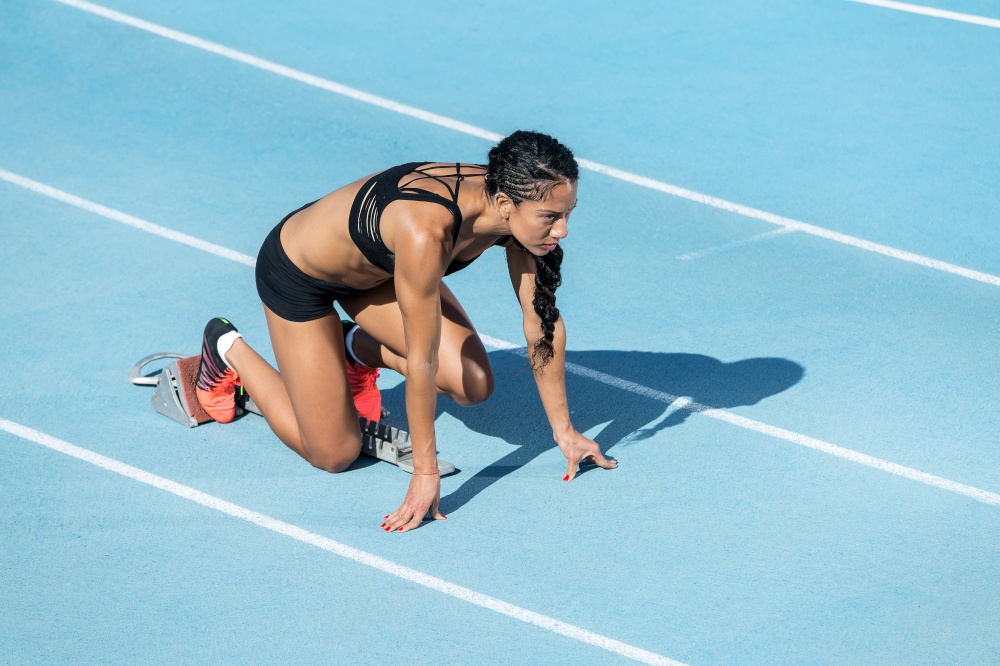 young and athletic woman practices exit on running track