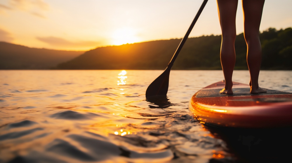 Person standing on SUP standup paddle board paddling into sunset. on lake. Person on SUP standup paddle board paddling into sunset on lake. Generative AI.