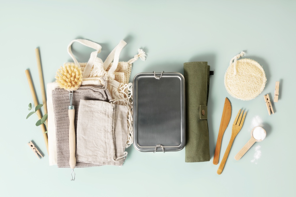 Set of reusable eco friendly products . Zero waste concept. Cotton bags, bamboo cutlery, straw, reusable cup and lunch box on pastel blue background, flat lay. Plastic free sustainable lifestyle concept
