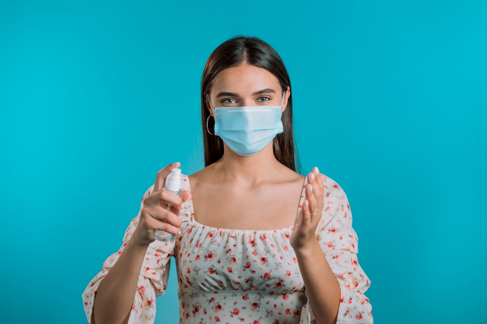 Woman in protective mask applies disinfectant antiseptic to her hands. Stop virus concept, bacteria protection. High quality photo. Woman in protective mask applies disinfectant antiseptic to her hands. Stop virus concept, bacteria protection.