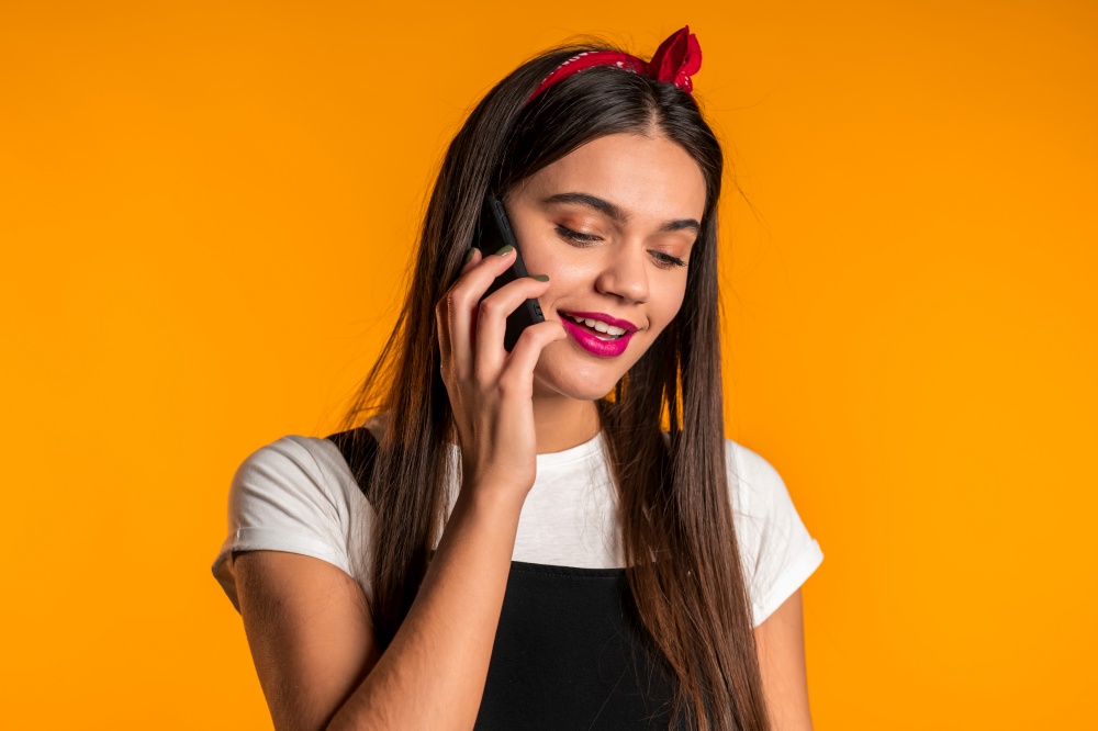Woman with long hair talking with somebody by mobile phone. Girl smiling, having pleasant conversation. Technology, mobile connection concept. Woman with long hair talking with somebody by mobile phone. Girl smiling, having pleasant conversation. Technology, mobile connection concept.