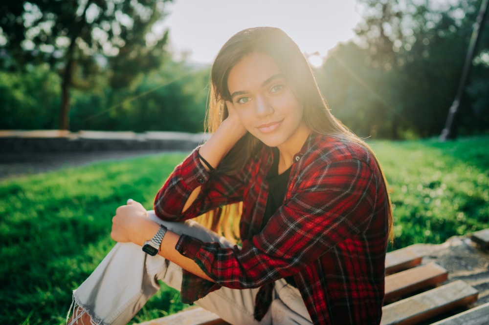 Young teenager&rsquo;s portrait. Girl in red plaid shirt smiles, enjoys life. Concept of student life, freedom, modern youth. Young teenager&rsquo;s portrait. Girl in red plaid shirt smiles, enjoys life. Concept of student life, freedom, modern youth.