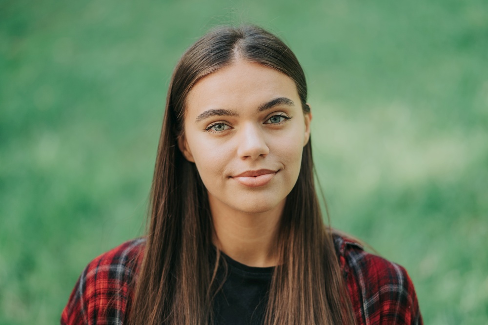 Young teenager&rsquo;s portrait. Girl in red plaid shirt smiles, enjoys life. Concept of student life, freedom, modern youth. Young teenager&rsquo;s portrait. Girl in red plaid shirt smiles, enjoys life. Concept of student life, freedom, modern youth.