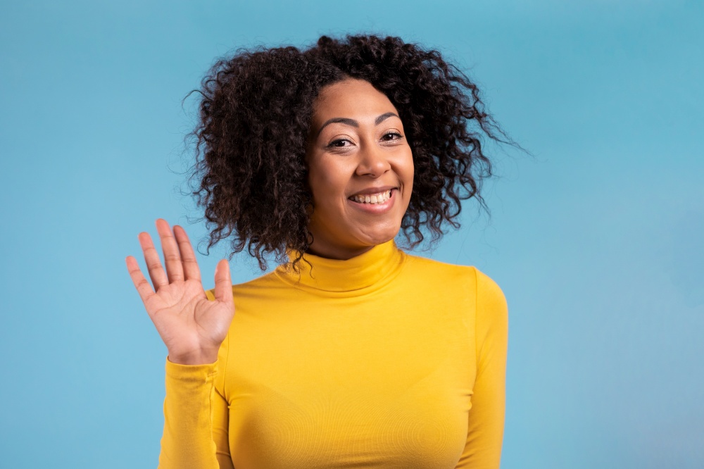 African friendly woman waving hand - hello. Greeting, say Hi to camera. Beautiful young girl on blue studio background. High quality. African friendly woman waving hand - hello. Greeting, say Hi to camera. Beautiful young girl on blue studio background. 4k