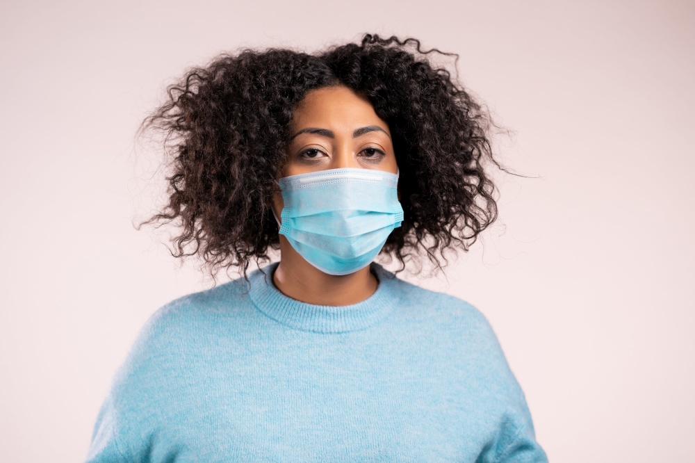 African woman in medical protective mask . Girl on white studio background. Coronavirus concept. High quality photo. African woman in medical protective mask . Girl on white studio background. Coronavirus concept.