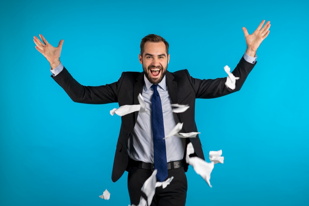 Serious businessman tearing contract in pieces. Angry furious male office worker throwing crumpled paper, having nervous breakdown at work, screaming in anger, stress management. businessman tearing contract pieces. Angry male worker throwing crumpled paper