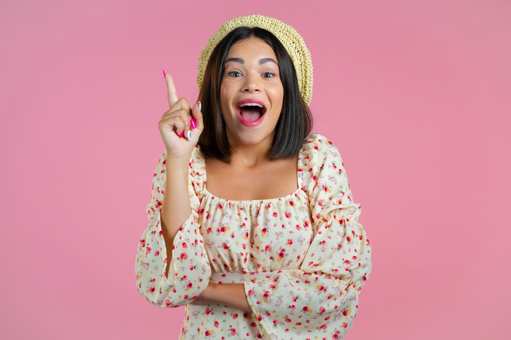 Portrait of young thinking pondering woman having idea moment pointing finger up on pink studio background. Smiling happy showing eureka gesture. Portrait of young thinking pondering woman having idea moment pointing finger up on pink studio background. Smiling happy showing eureka gesture.