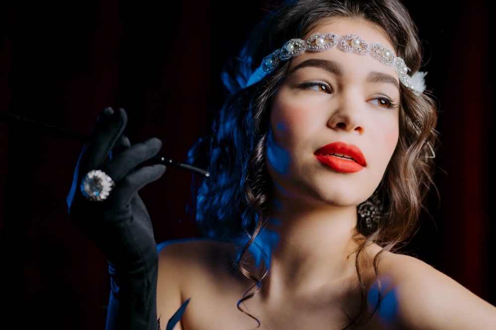 Portrait of brunette woman dressed in style of Great Gatsby flirting and posing on velours background. Roaring twenties, retro, party, fashion concept. High quality photo. Brunette woman with mouthpiece cigarette dressed in style of twenties years flirting and posing on velours background. Roaring twenties, retro, party, fashion concept