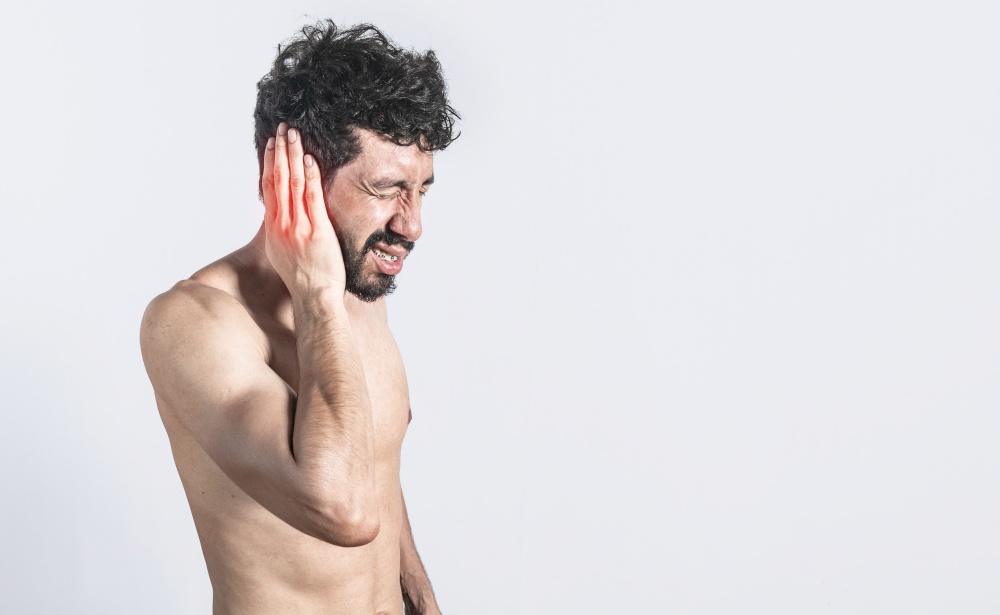 Person with earache on isolated background, man with earache on isolated background, ear disease concept