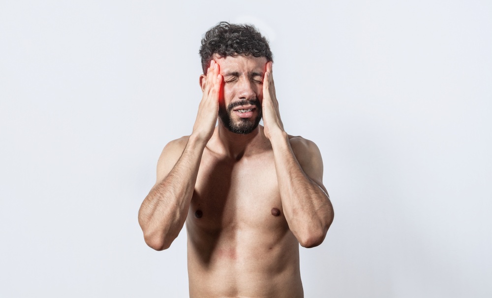 Shirtless man with headache, person with headache on isolated background, man in pain holding his head, migraine man concept