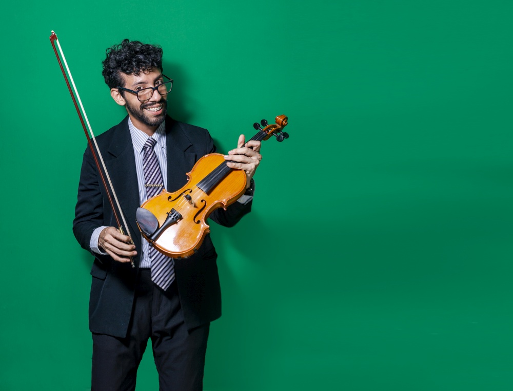 Portrait of a smiling violinist man isolated, Smiling violinist man looking at camera and holding his violin, Violinist man concept on isolated background