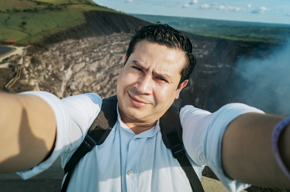 Adventurous people taking a selfie at a viewpoint. Close up of person taking an adventure selfie, Tourist taking a selfie at a viewpoint. Handsome tourist taking a selfie on vacation