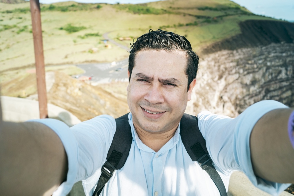 Close up of man taking an adventure selfie, Tourist taking a selfie at a viewpoint. Adventurous people taking a selfie at a viewpoint. Handsome tourist taking a selfie on vacation