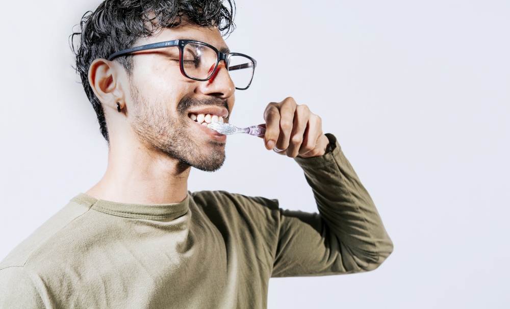 Man brushing his teeth isolated, Face of handsome man brushing his teeth with copy space. Tooth care and brushing concept. Face of person brushing teeth isolated with copy space