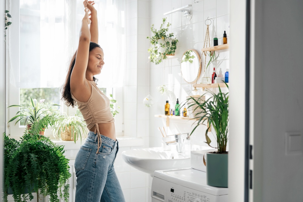 Young woman stretching in bathroom. Body positivity, confort home zone, wellness and lifestyle. Young woman stretching in bathroom