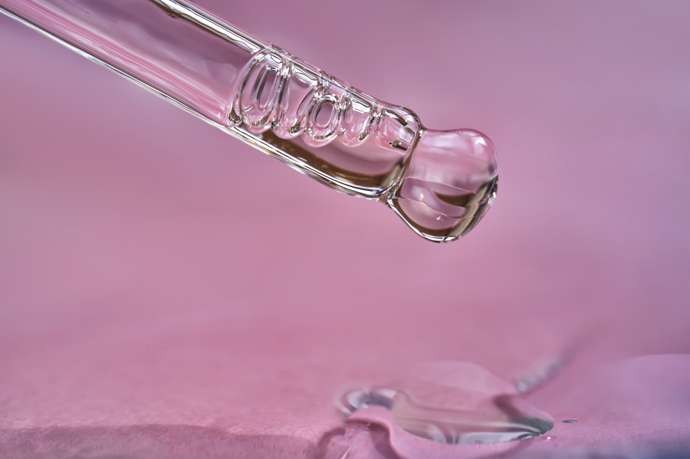 Dropper with serum or cosmetic oil on a pink background. A great photo for your business.. Dropper with serum or cosmetic oil on a pink background.