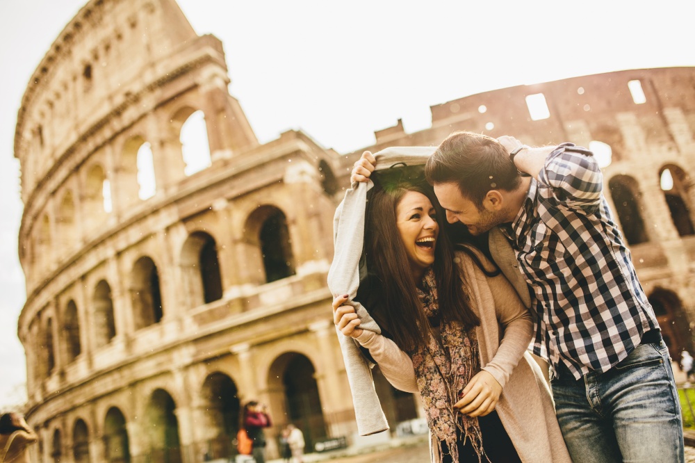 Loving couple in front of the Colosseum in Rome while raining