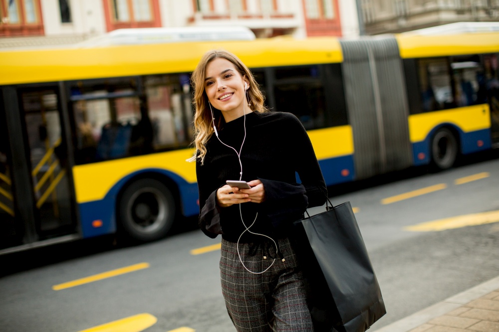Portrait of young woman waiting for taxi or bus on the street in the city
