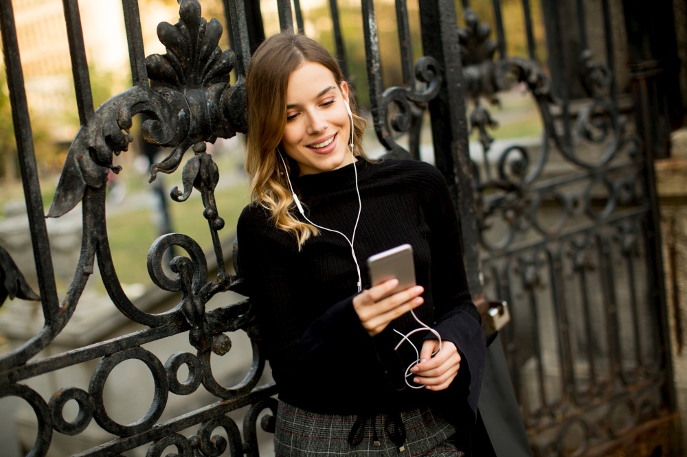 Portrait of young woman  listening music outdoor